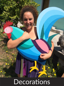 A happy woman holding the colorful wooden rooster made of plywood and hand painted.  Because of accurate tracing by the drawing robot, this DIY project was easy to realize with successful outcome.